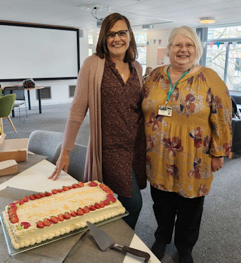 a photo of Helen and Mary stood with a cake